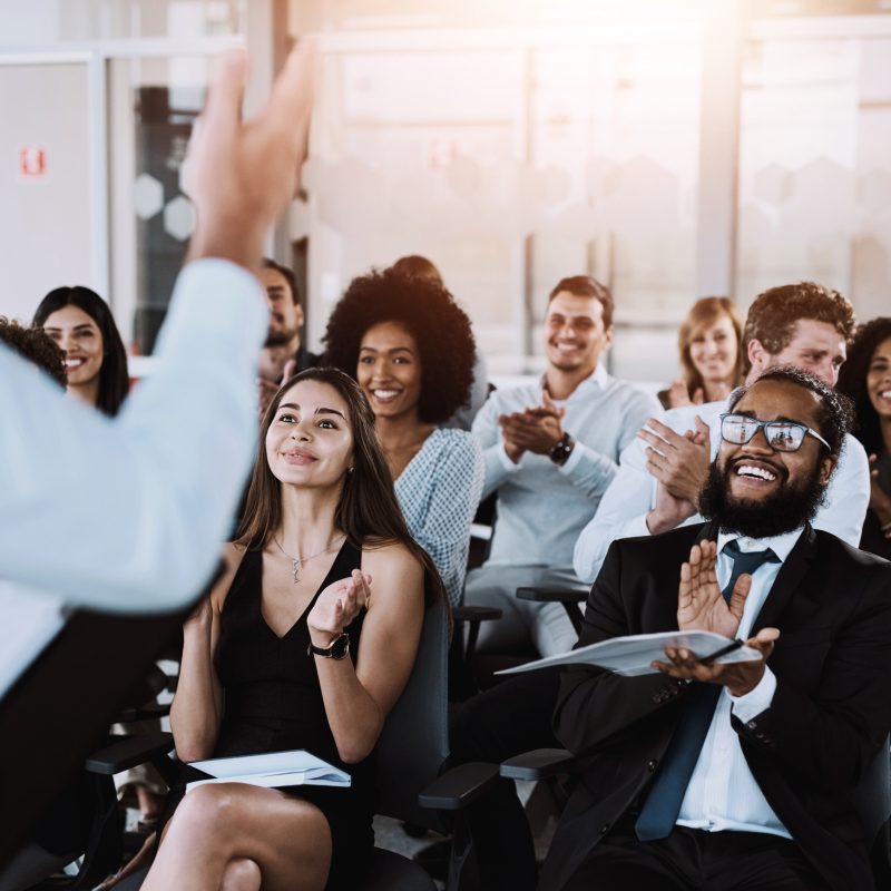 People, speaker and applause at workshop in office for training, support for company conference or event. Celebrate, inclusion presentation and corporate award for team building with staff at seminar